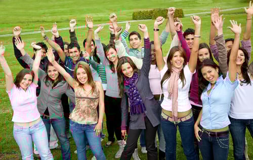 casual students smiling and celebrating success in a park