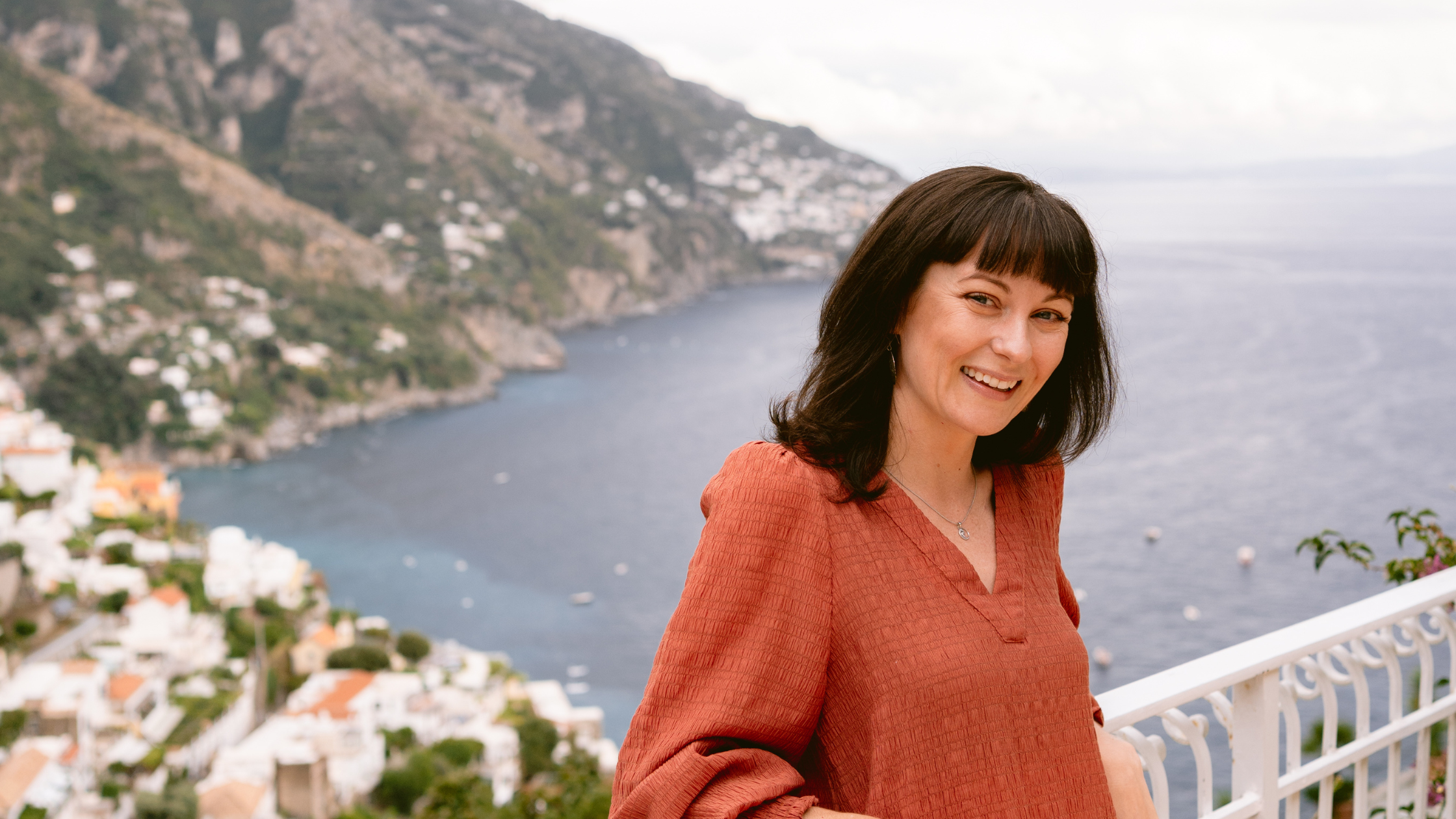 Erin Aquin in Positano, Italy smiling on a balcony